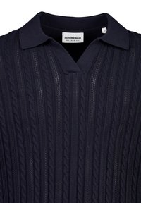 Πουκάμισο polo από βαμβακερή πλέξη σε ναυτικό μπλε, με άνετη εφαρμογή, διαθέτει σχέδιο καλώδιο και κοντό, ανοιχτό γιακά. Η ετικέτα δείχνει μέγεθος μεσαίο.