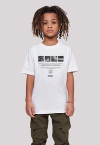 Weißes Baumwoll-T-Shirt mit NASA-Grafiken, einschließlich Bildern und Text. Der Träger trägt braune Cargo-Hosen und hat Dreadlocks.