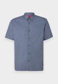 Kortärmad skjorta med knappar i en skifferblå färg, med en spetsig krage, svarta knappar och en liten röd logotyp vid fållen.