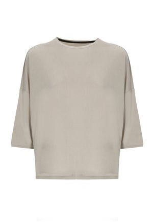 Camicia beige oversize a maniche corte con scollo rotondo e spalle scese, mostrata su sfondo bianco.
