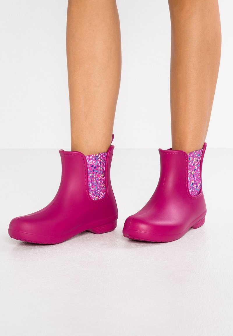 Stivali da pioggia in gomma rosa con dettagli laterali in tessuto glitterato e testurizzato. Il design presenta una punta arrotondata e un tacco basso.