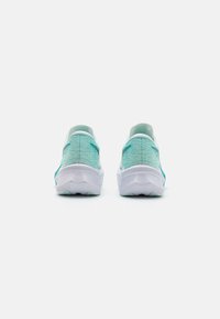 Des chaussures de sport aqua et blanches avec un dessus texturé, un bout arrondi, une semelle intermédiaire rembourrée et un motif de semelle en caoutchouc distinctif.