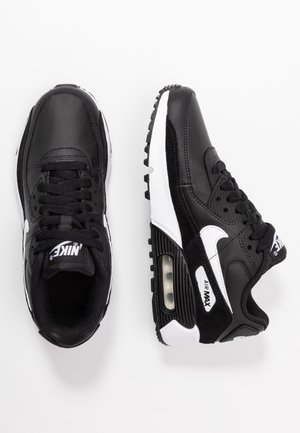 Sorte Nike Air Max sneakers har en overdel af læder, hvide detaljer, teksturerede sider, luftdæmpning synlig i sålen og runde snørebånd.