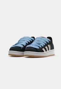 Black suede sneakers with blue laces, white stripes, and a white rubber sole. Features a textured upper and gum rubber outsole.