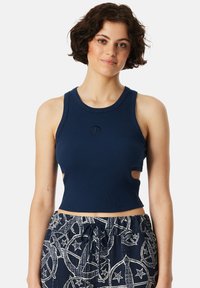 Marineblauw geribbelde crop top met uitsnijdingen, ronde halslijn en geborduurd logo op de borst, gecombineerd met gestreepte broek met trekkoord.