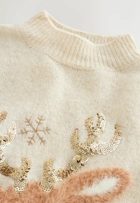 Beige sweater med ribbet halsudskæring, prydet med gyldne palietter formet som rensdyrhorn, en snefnugsdesign og bløde, fluffy detaljer.