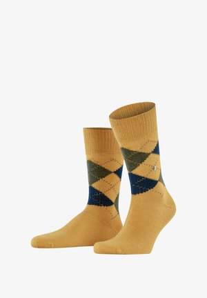 Żółte skarpetki w wzór argyle w odcieniach zieleni i granatu, z prążkowanym mankietem, teksturowanym splotem i małym akcentem w postaci srebrnego logo.