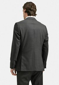 Mäns mörkgrå kostymjacka, skräddarsydd passform, mjuk textur, enkel sprund och tre-knapprig detalj på ärmarna, sedd från baksidan.