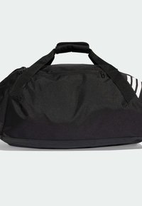 Bolsa de lona negra con asas acolchadas y compartimentos con cremallera, con rayas diagonales blancas en un lado.