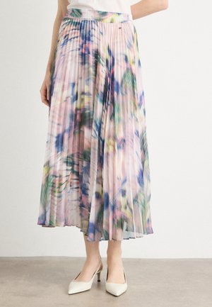 Pleated midi skirt with multicolor abstract floral pattern worn with white heels and a white top, shown from waist to feet.