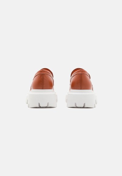 Brune lærersneakers med en chunky hvid gummisål. Har en rund bagdel og en glat overflade, velegnet til afslappet brug.