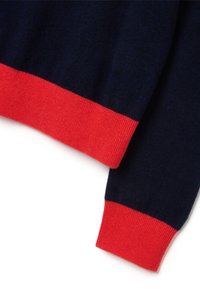 Maglione di lana blu navy con polsini e orlo a coste rossi. Tessuto morbido con un design semplice, caratterizzato da un gioco di colori vicino ai bordi.