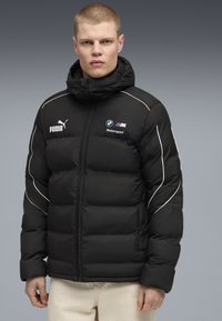 Sort dunjakke med hætte, med hvid piping, Puma- og BMW Motorsport-logoer på fronten, og med lynlås.
