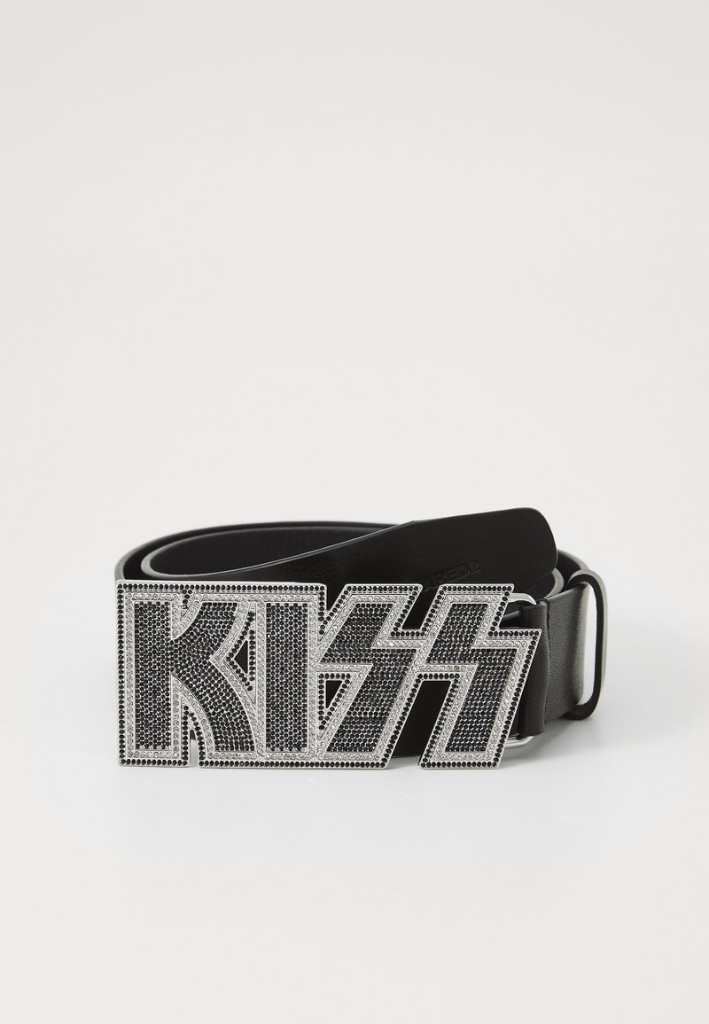 Melna ādas josta ar rhinestone izrotātu sudraba sprādzi, uz kuras ir vārds "KISS" stilizētā fontā un zibens forma.