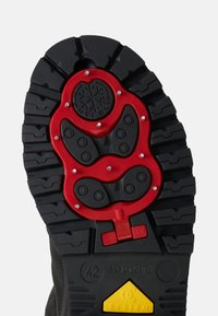 Schwarze Gummistiefelsohle mit auffälligem rotem Verriegelungsmechanismus, strukturiertem Profil und gelbem Akzent. Größe 42 an der Seite markiert.