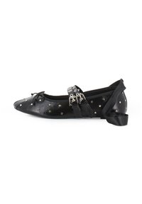 Bailarina de cuero negro con remaches plateados, punta afilada, detalle de lazo con cordones y correas de cuero dobles con hebillas metálicas.
