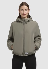 Lightweight, olive-green puffer jacket with a hood, elasticized cuffs, front zipper, and a small branded tag at the hem.