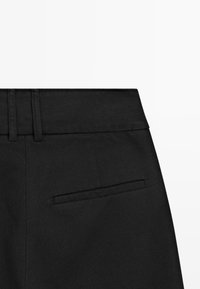 Pantaloni neri con una texture liscia, caratterizzati da una fascia in vita piatta e una tasca posteriore singola con bordo cucito pulito.