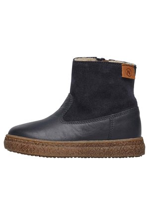 Bottines en cuir noir avec un dessus en daim, semelle brun texturée et une petite étiquette logo beige à l'arrière. Équipées d'une fermeture éclair sur le côté pour un enfilage facile.