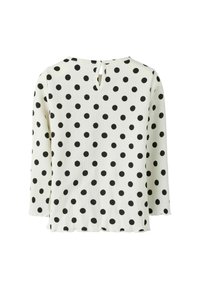 Witte blouse met zwarte stippen, met een keyhole rug, lange mouwen en een textuurstof. De zoom is lichtjes gegolfd.