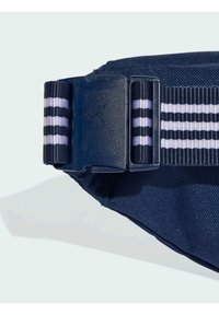 Navy blue nylon waist bag featuring a textured surface, horizontal striped strap in black and white, and a plastic buckle closure.