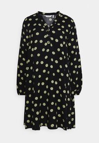 Musta mekko, jossa on pitkät hihat ja V-aukko, vihreillä pilkuilla, kolmonen nappi kaula-aukossa ja levenevä lantio.