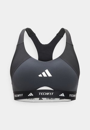 Fekete és sötétszürke Adidas Techfit sportmelltartó versenyzői hátformával és elasztikus szalaggal, amelyen az Adidas logó és a „TECHFIT” felirat látható.