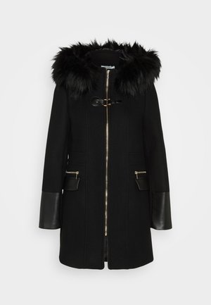 Black coat featuring a faux fur hood, gold zipper, and two zippered front pockets. Leather sleeves and accents enhance the design.