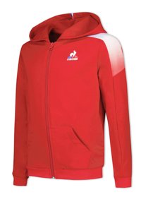 Sudadera con cremallera roja con un acento blanco en el hombro, bolsillos delanteros y un logo. Confeccionada con un material suave, tiene un corte estándar y capucha.