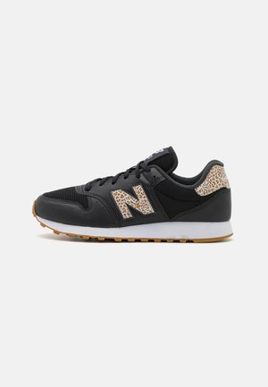 Sneaker sportivo nero con accenti in stampa leopardata sul logo laterale e sul tallone, sole intermedio bianco e suola in gomma naturale, vista laterale.