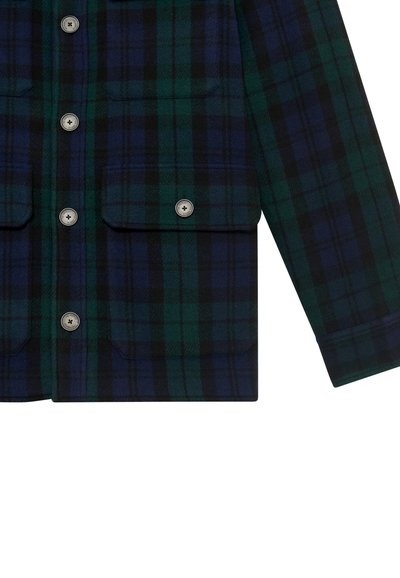 Kék és zöld kockás dzseki gombos záródással és négy elülső zsebbel, fehér háttér előtt bemutatva.