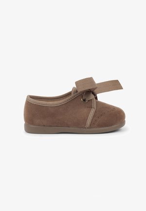 Chaussure en suède marron avec un bout rond, un col en tissu élastique et un accent de nœud. Possède des détails perforés et une semelle en caoutchouc flexible.