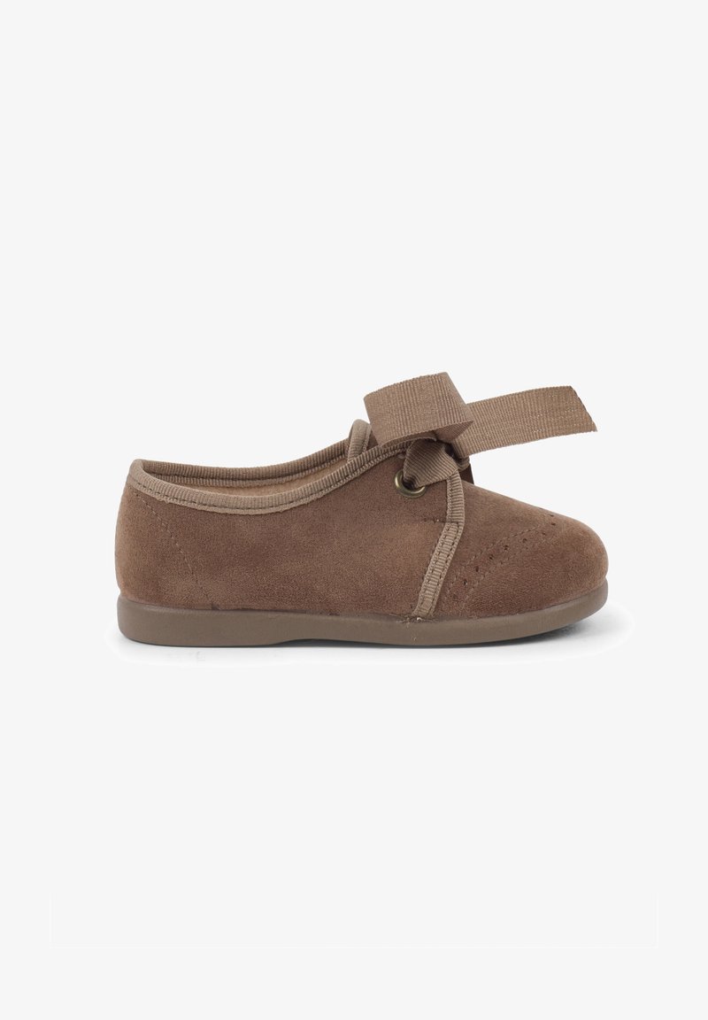 Scarpa in suede marrone con punta rotonda, colletto in tessuto elasticizzato e dettaglio a fiocco. Presenta dettagli perforati e una suola in gomma flessibile.