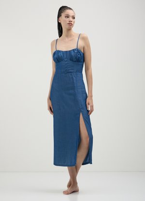 Robe en denim avec des bretelles spaghetti, un buste ajusté et une fente sur le côté. Le tissu a une texture lisse et une profonde couleur bleue avec des détails de boutons.