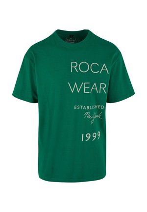 Groenen katoenen T-shirt met ronde hals; bevat "ROCA WEAR" in grote letters en kleinere tekst met "OPGERICHT New York 1999."