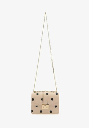 Bolso bandolera beige con lunares negros, cierre dorado y cadena dorada colgando sobre un fondo blanco.