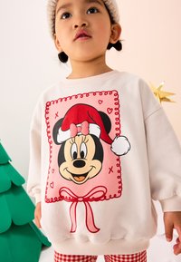 Felpa bianca con una grande grafica di Topolino con un cappello da Babbo Natale, contornato da una linea rosa, con cuori rossi e un motivo a fiocco.