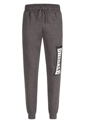 Grå sweatpants lavet af blødt stof, med en elastisk talje og snore og et stort logo trykt i hvidt på siden.