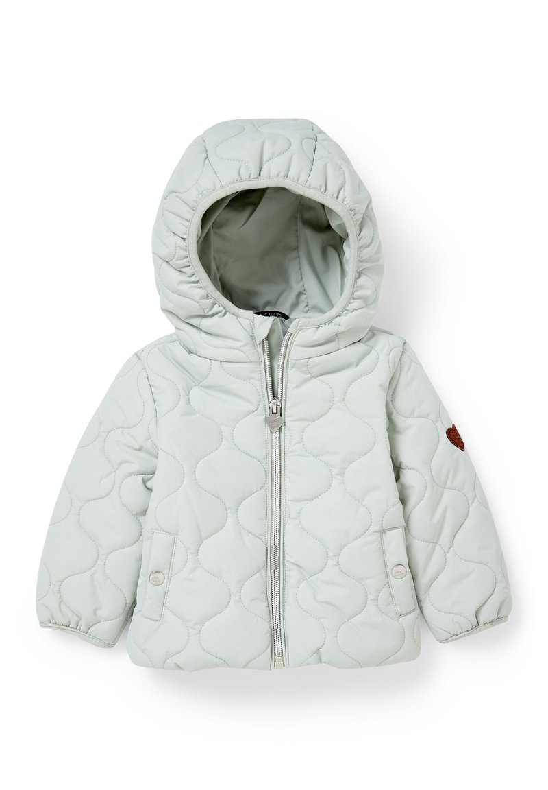 Giacca trapuntata verde chiaro con cappuccio, dotata di zip frontale, polsini elastici e una patch decorativa marrone sulla manica.