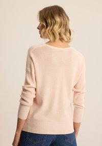 Jasnoróżowy sweter z dzianiny o luźnym kroju, z prążkowanymi mankietami i dołem, z gładką fakturą i szerokim dekoltem.
