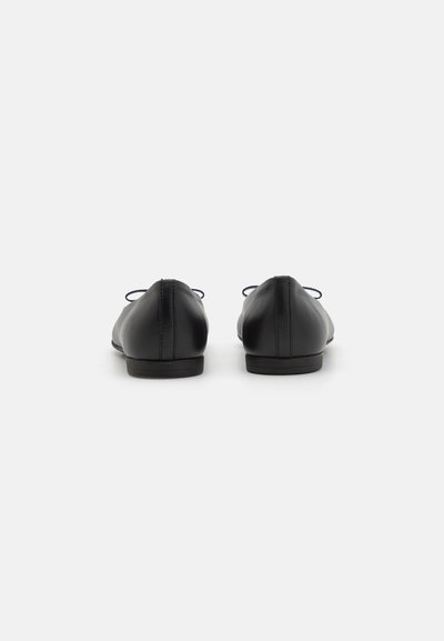 Bailarinas de cuero negro con una textura suave, tacón bajo y detalles de encaje en la parte posterior, que presentan un diseño minimalista.