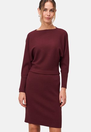 Robe en tricot bourgogne avec une texture côtelée, présentant une encolure bateau, des manches longues et une silhouette de jupe ajustée.