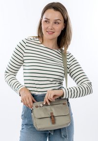 Borsa a tracolla rettangolare in tessuto grigio con patta e dettaglio fibbia marrone. Presenta una tasca con zip e una tracolla regolabile.