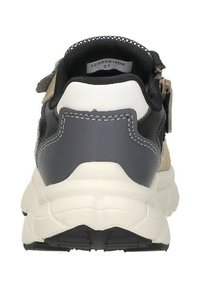 Achteraanzicht van een sneaker met gestructureerde beige, marineblauwe en witte materialen; gewatteerde kraag; versterkte hiel; en een geribbelde zwarte zool.