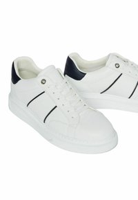 Sneakers in pelle bianca con una finitura testurizzata, caratterizzati da accenti neri sul tallone e sul lato, lacci rotondi e una suola ammortizzata.