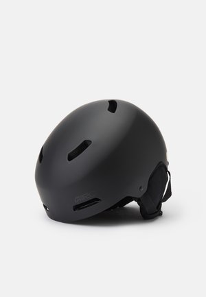 Schwarzer Helm mit mattierter Oberfläche, runder Form, mehreren Belüftungslöchern, weicher Innenpolsterung und verstellbarem Riemen an der Seite.
