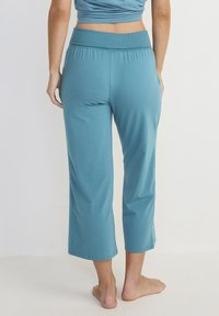 Teal cropped pants met een brede elastische tailleband, een gladde textuur en een comfortabele pasvorm. Bevat een eenvoudig ontwerp zonder extra details.
