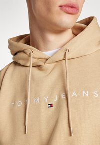 Tommy Jeans LINEAR LOGO - Športni pulover - tawny sand
