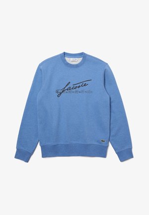 Blaues Sweatshirt mit Rundhalsausschnitt, schwarzer "Lacoste"-Schriftzug und kleinem grünem Krokodil-Logo nahe dem Saum auf der linken Seite.
