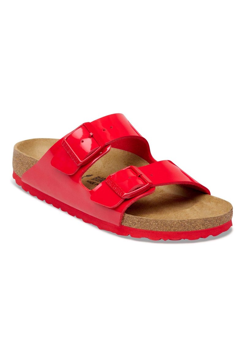 Rote offene Sandale mit zwei verstellbaren Riemen und Schnallen, Kork-Fußbett und roter strukturierter Gummisohle.